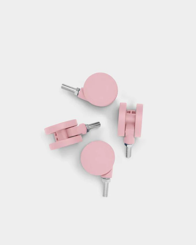 Set of four Bubble Gum pink caster wheels with threaded metal bolts, arranged on a light grey studio backdrop