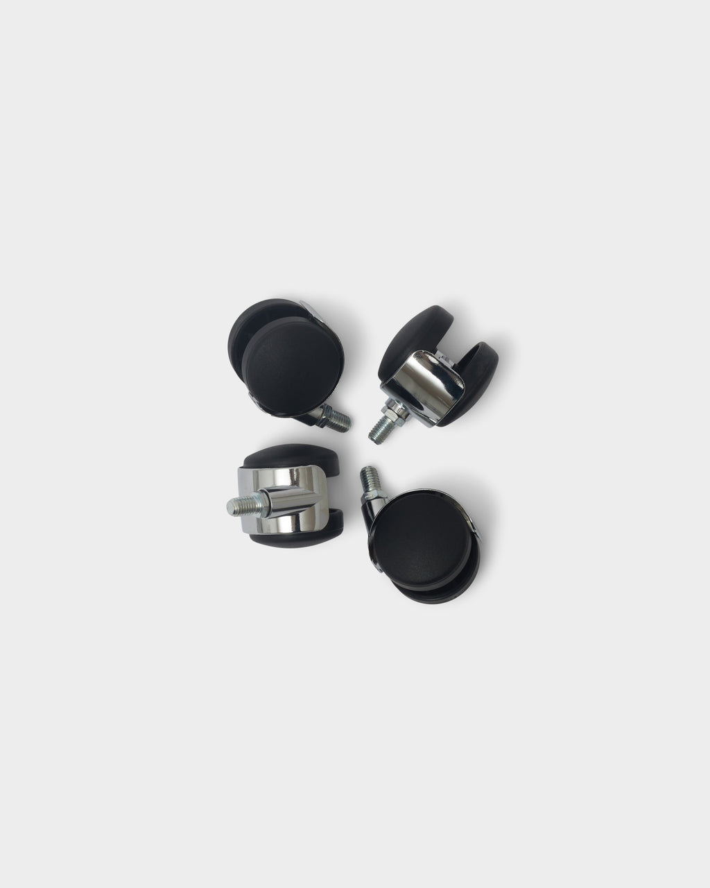 Set of four chrome Wheels casters with black swivel treads and threaded stems, arranged in a circle on a studio backdrop