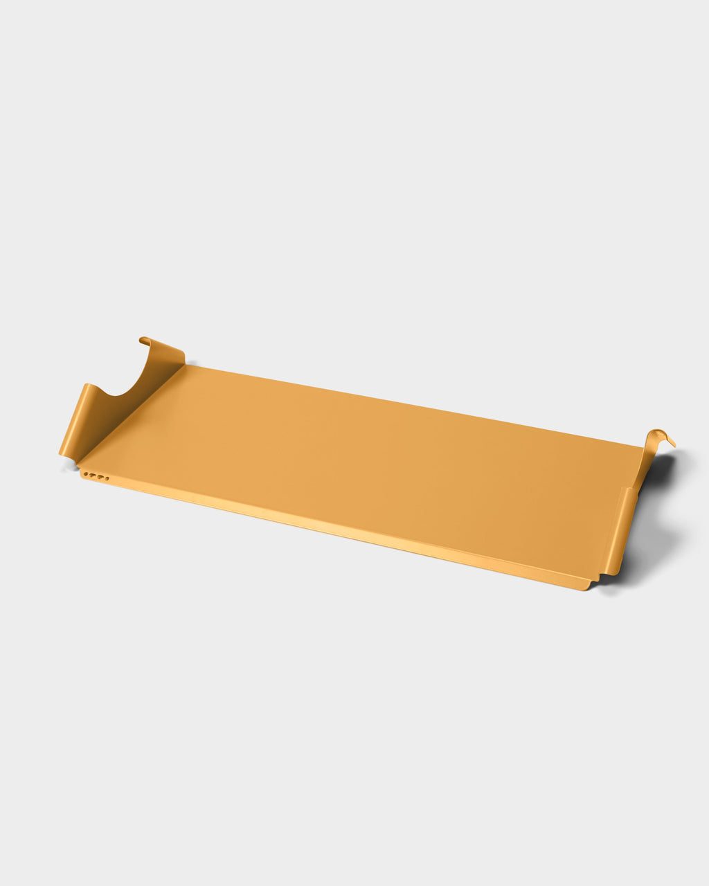 Moon Tray Shelf in apricot shown at an angle on a light studio backdrop, highlighting its folded metal edges and hooks
