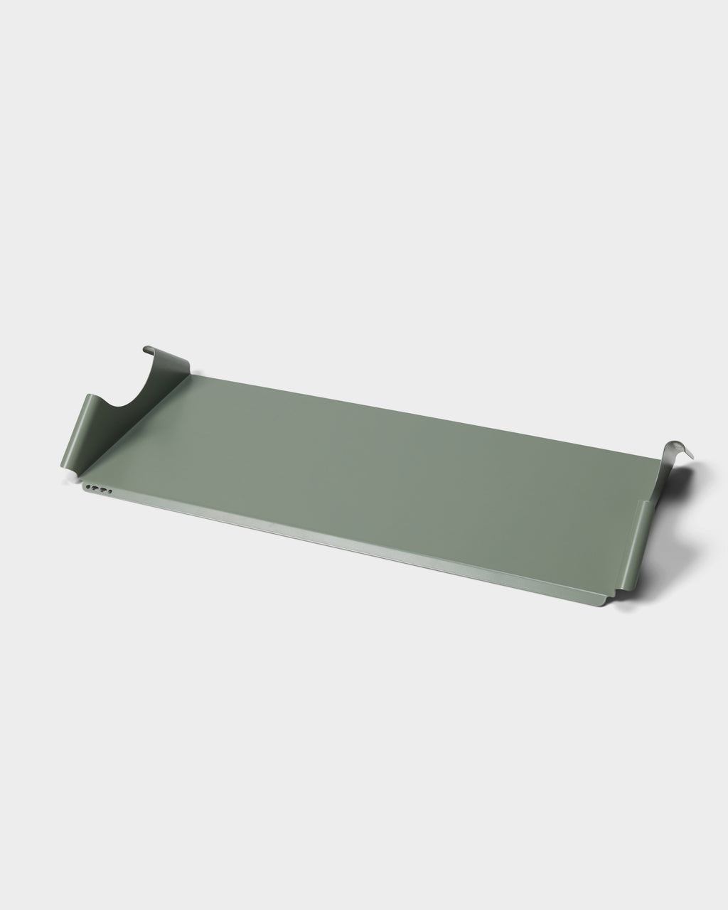 Moon Tray Shelf in Mossy Green shown at an angle in a studio packshot, revealing its curved hook ends and vent slots