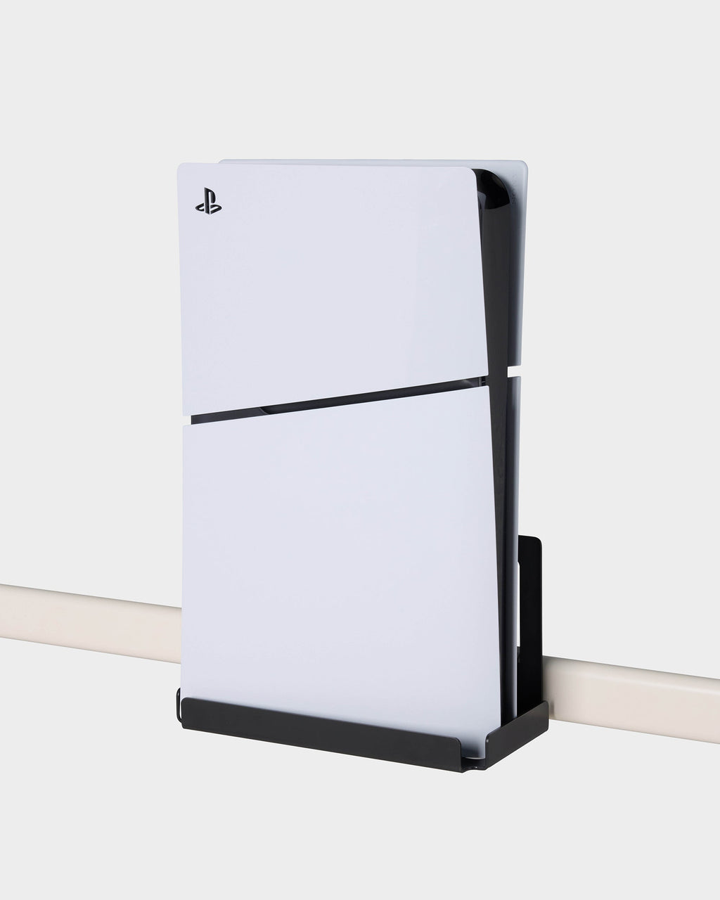 Charcoal PS5 Slim Mount holding a white console vertically on a wall rail, angled studio side view