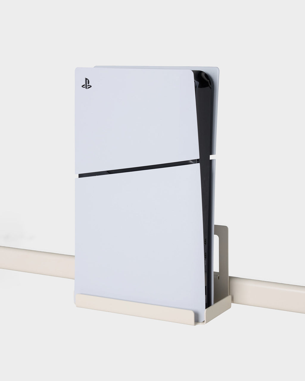 Pearl PS5 Slim Mount holding a white console vertically on a wall rail, angled side view against a light studio backdrop