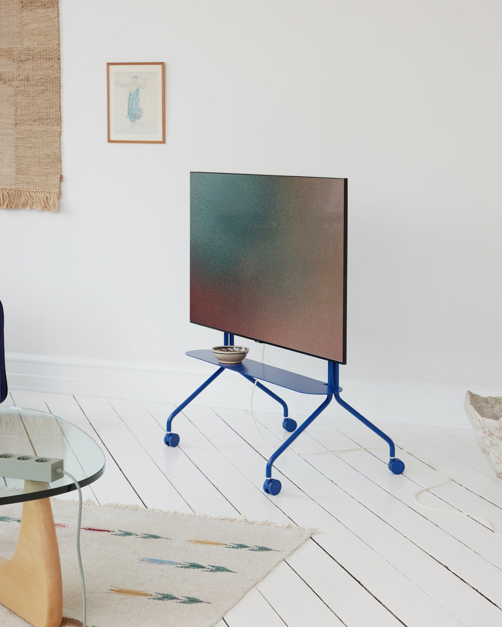 Moon Shelf in Ultra Marine on a rolling TV stand in a bright living room, holding a small ceramic bowl