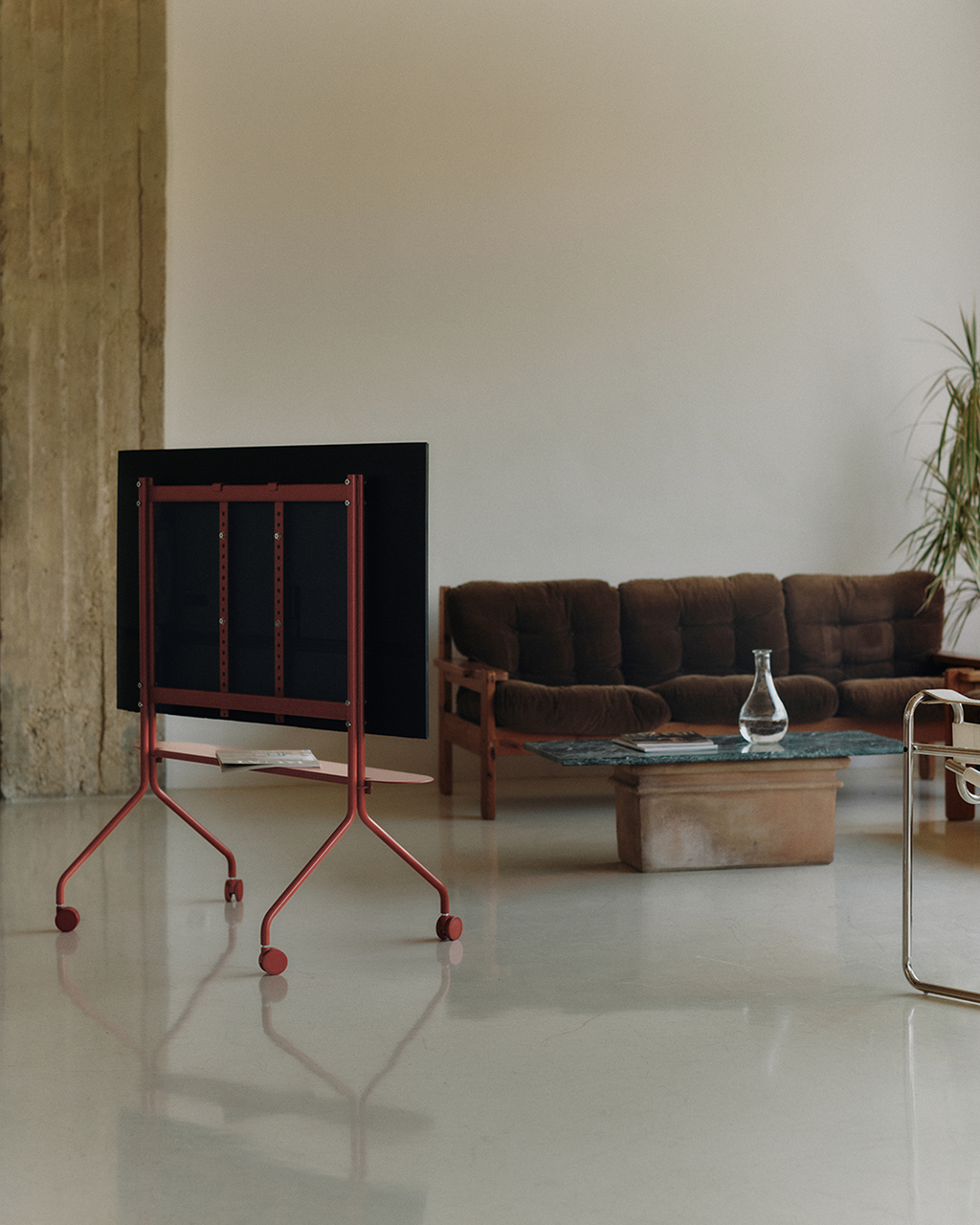 Moon Shelf in Burnin' Red on a rolling TV stand in a loft living room, rear view with magazines on the shelf