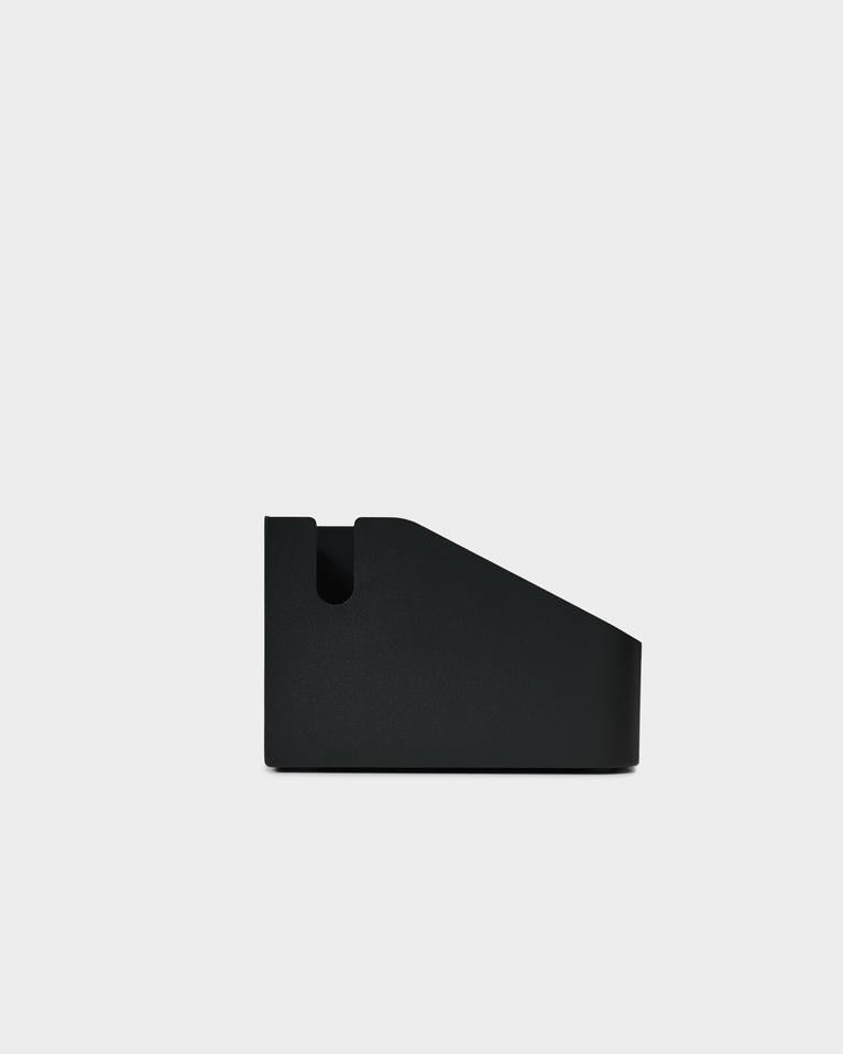 Side profile studio packshot of the charcoal Power Bar Tray, showing its angled wedge shape and cord cutout