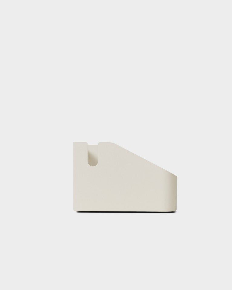 Side profile studio packshot of the Power Bar Tray in Pearl, showing its sloped wedge shape and cord notch