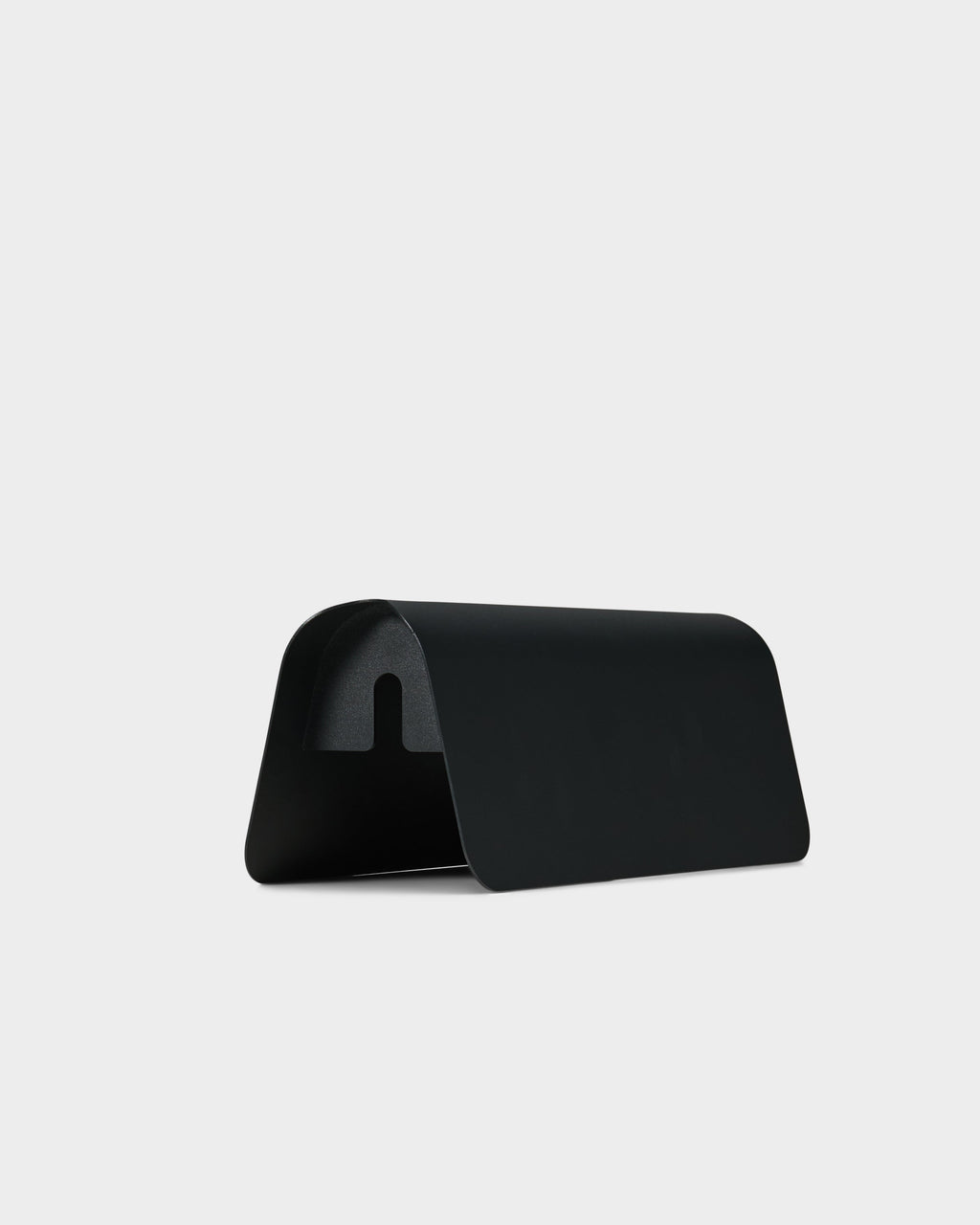 Power Shell in Charcoal studio packshot from a rear angle, curved metal cover showing arched cable cutout underneath