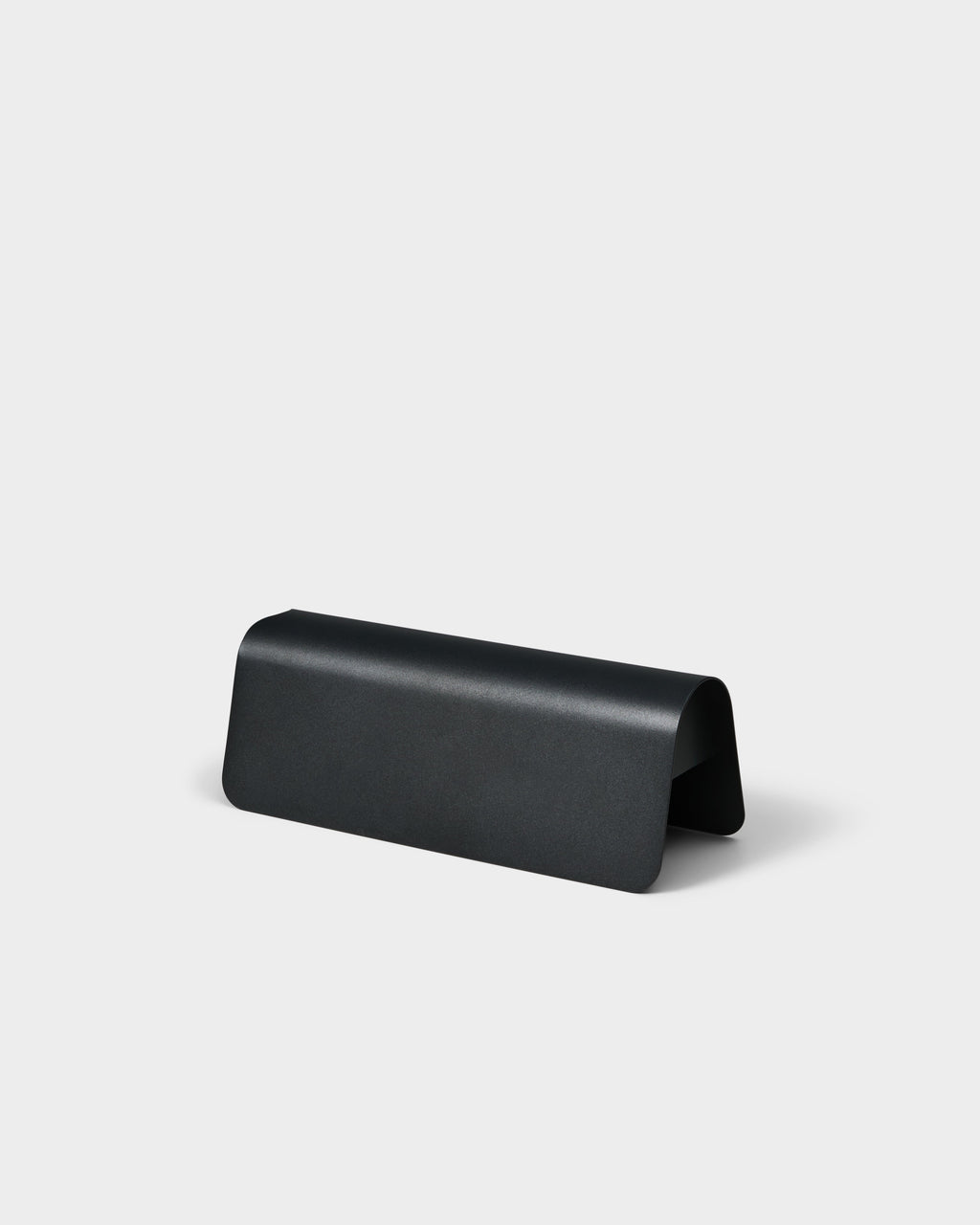 Power Shell in Charcoal, a curved matte metal cable cover shown at an angle in a plain studio packshot
