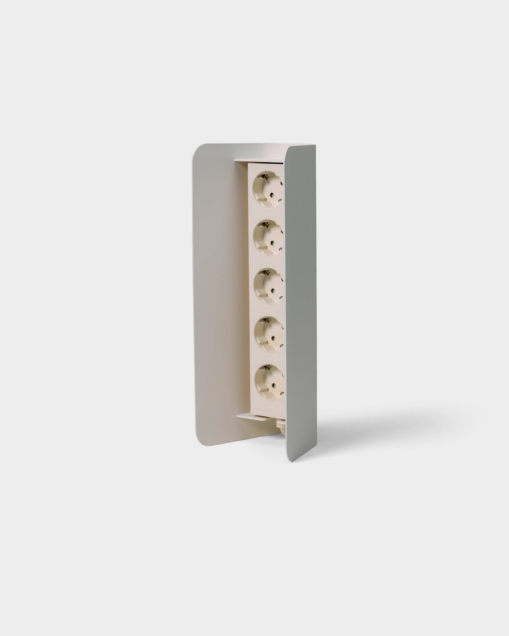 Angled studio packshot of Power Shell in Pearl, curved metal cover revealing five vertical Schuko sockets inside