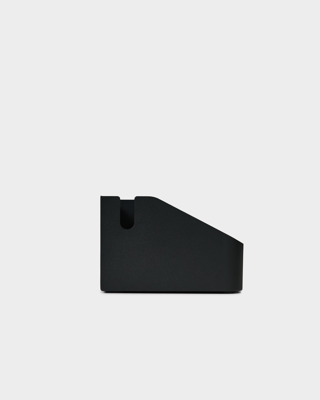 Side profile studio packshot of the Power Beam Tray in Charcoal, showing its angled wedge shape and cable notch