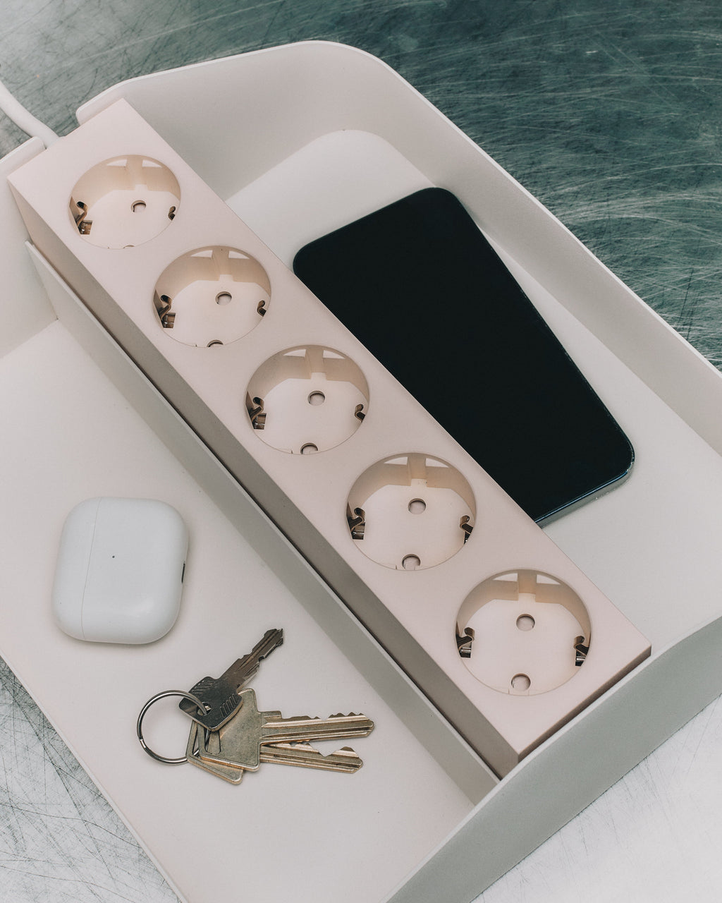 Power Beam Tray Double in Pearl holding a phone, keys and earbuds case, angled overhead lifestyle view on a desk