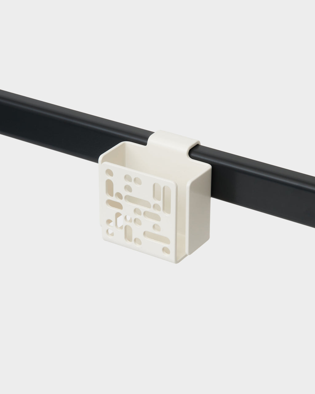 Pearl Remote Box Mount clipped onto a black rail in a studio packshot, angled view showing perforated front panel