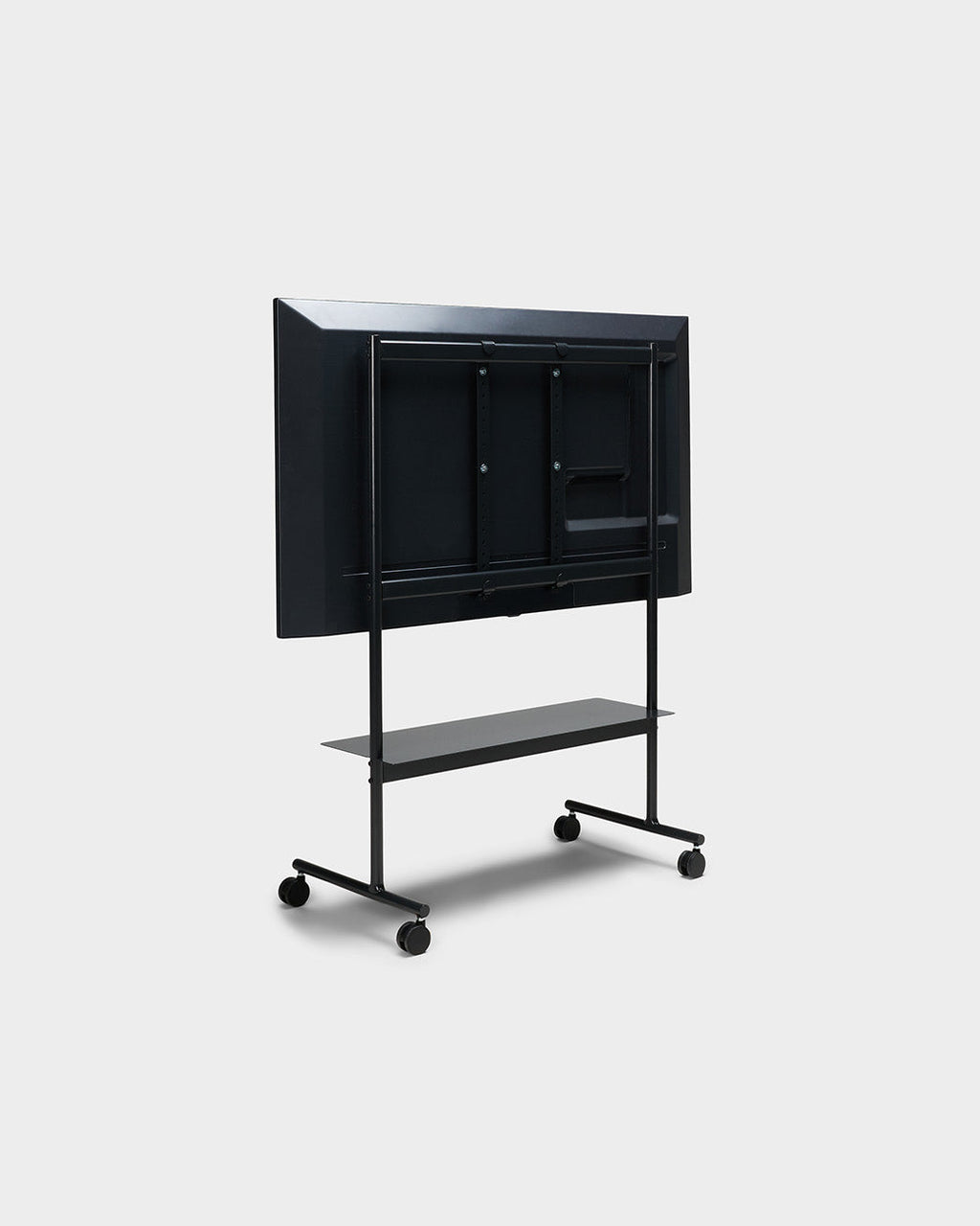 Rear view of the Rover stand in Charcoal with mounted display, lower shelf and locking wheels on a studio background