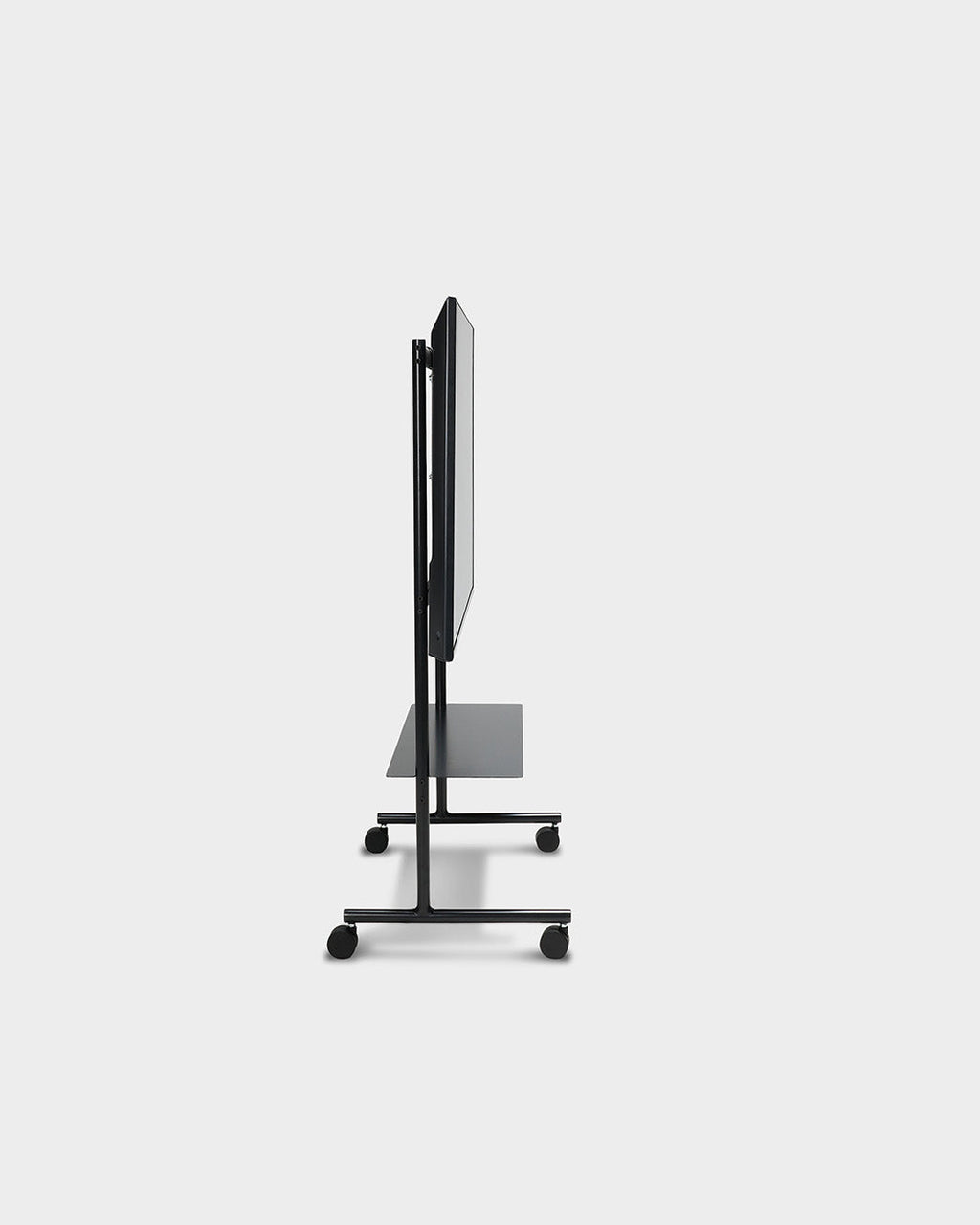 Side profile of the Rover TV stand in Charcoal, studio packshot showing slim mounted display, shelf and locking wheels