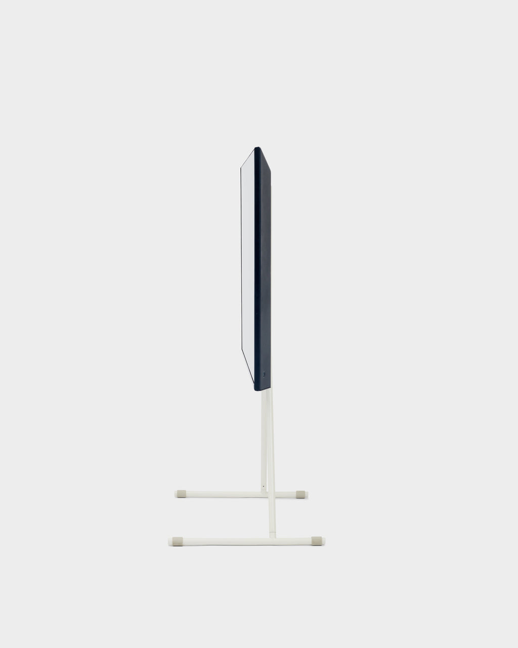 Side profile studio shot of the Viva TV stand in Pearl, slim white poles on twin T-bases holding a mounted flat screen