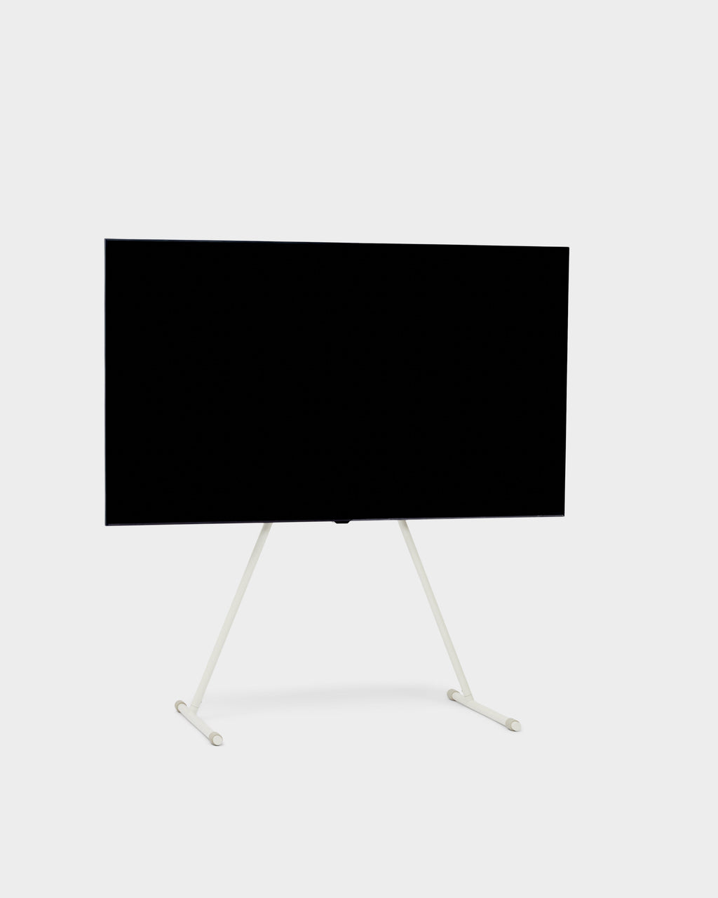 Viva TV stand in Pearl holding a large flat-screen TV, angled studio packshot showing slim splayed legs and wheels