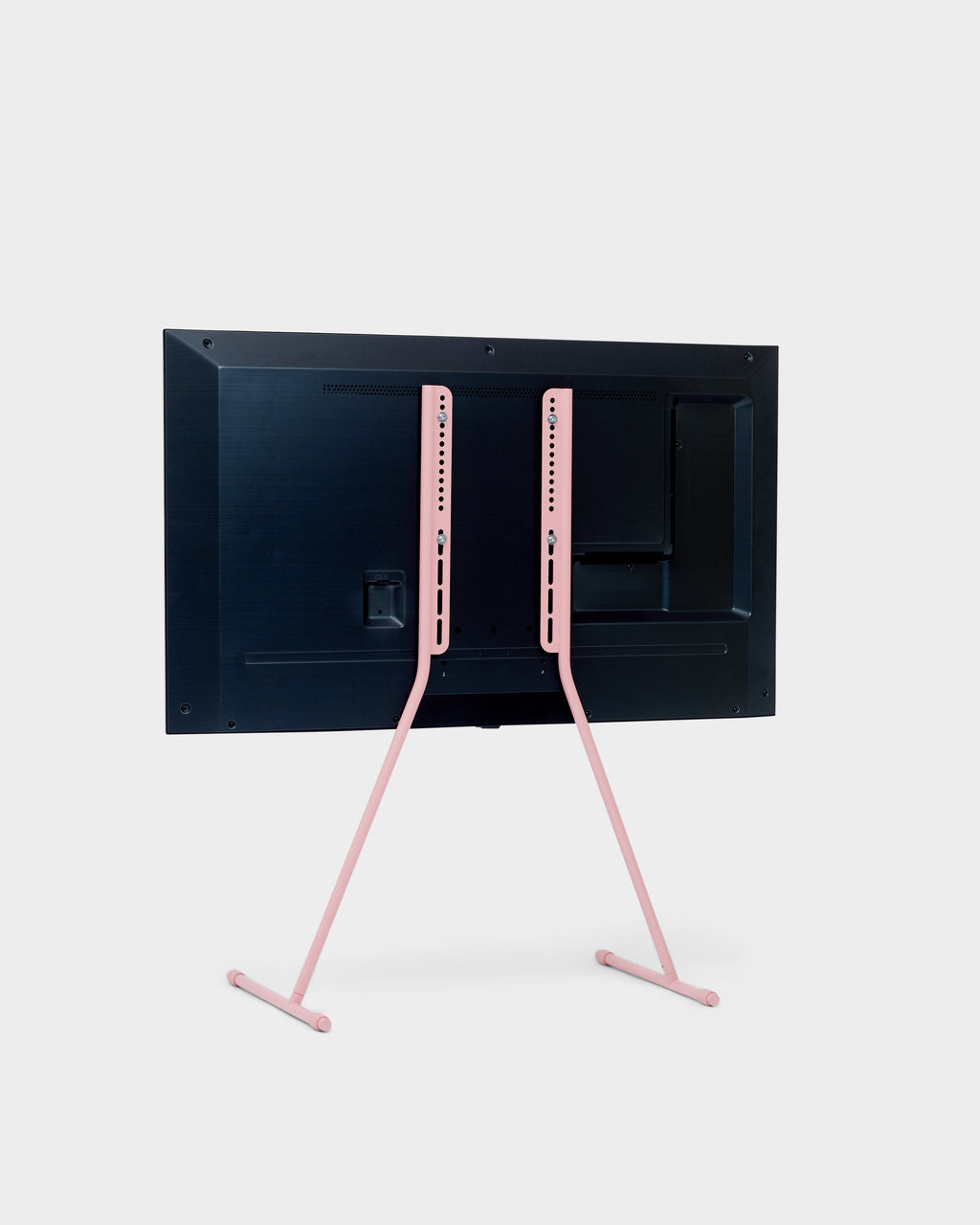 Rear view of Viva TV stand in Bubble Gum pink holding a mounted flat-screen TV, studio packshot on light grey