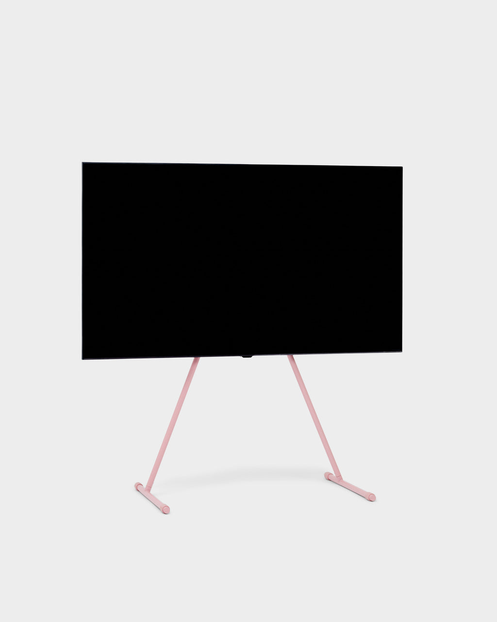 Viva TV stand in Bubble Gum pink holding a large flat-screen TV, angled studio packshot on light grey background