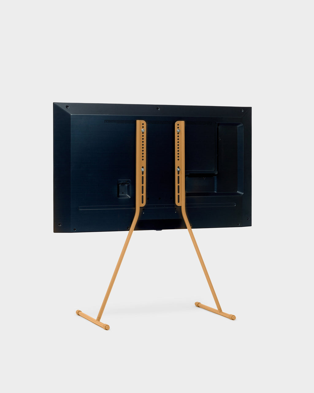 Rear three-quarter view of the Viva TV stand in Apricot holding a mounted flat-screen TV, studio packshot