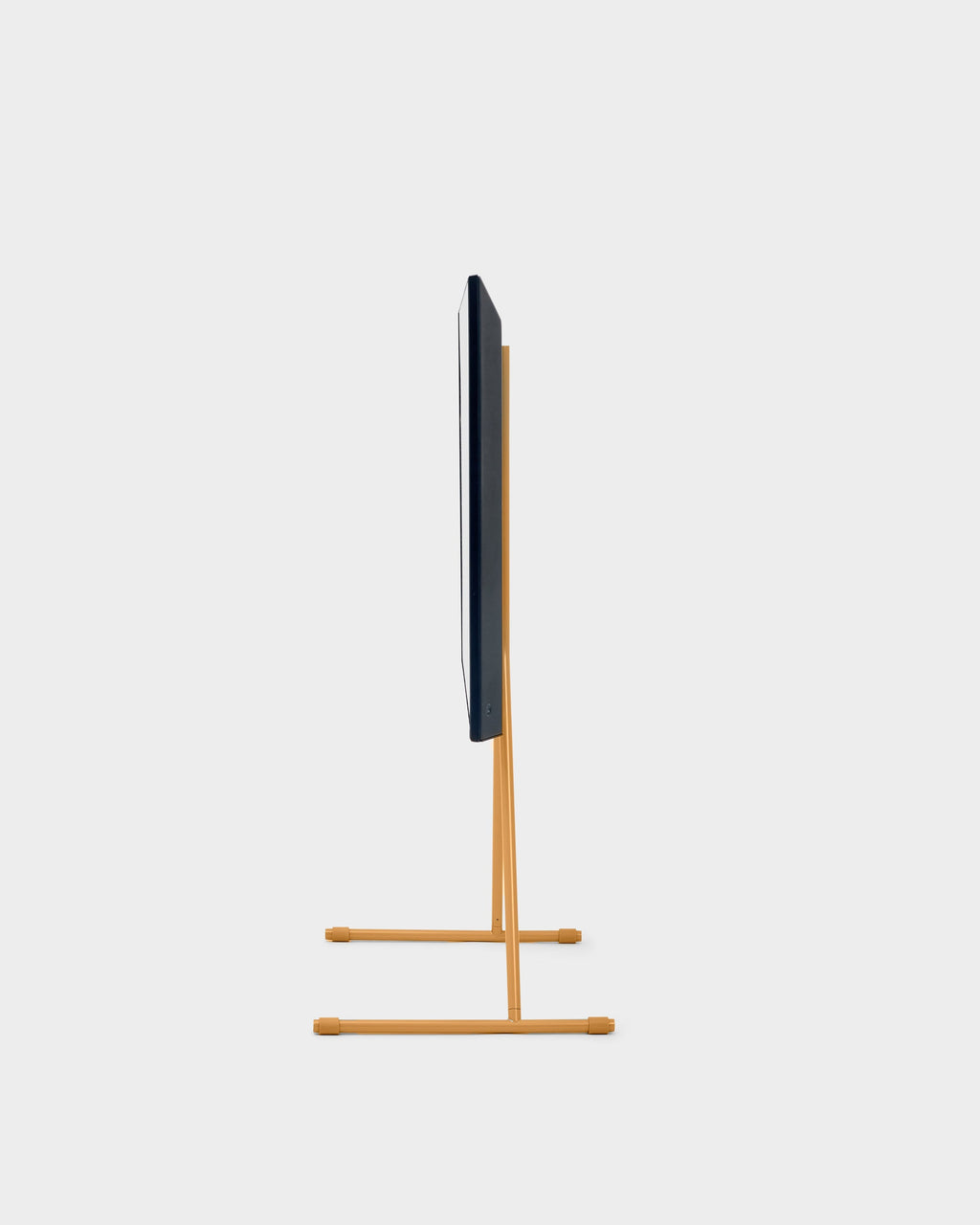 Side profile studio shot of the Viva TV stand in apricot, slim easel legs supporting a mounted flat-screen TV