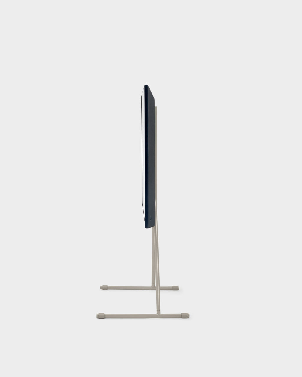 Side profile of the Viva TV stand in Oat holding a slim flat-screen TV, studio packshot on a light gray background