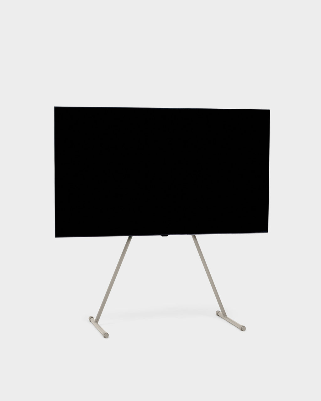 Viva TV stand in Oat holding a large flat-screen TV, angled studio packshot showing slim splayed legs