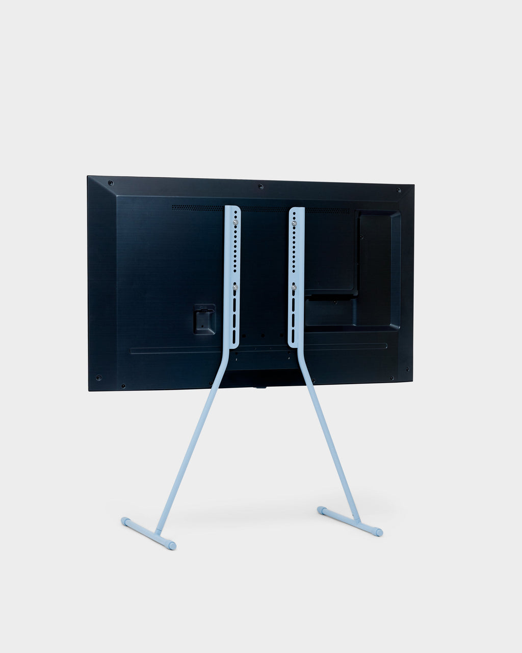 Rear view of the Viva TV stand in Powder Blue holding a mounted flat-screen TV, slim splayed legs, studio packshot