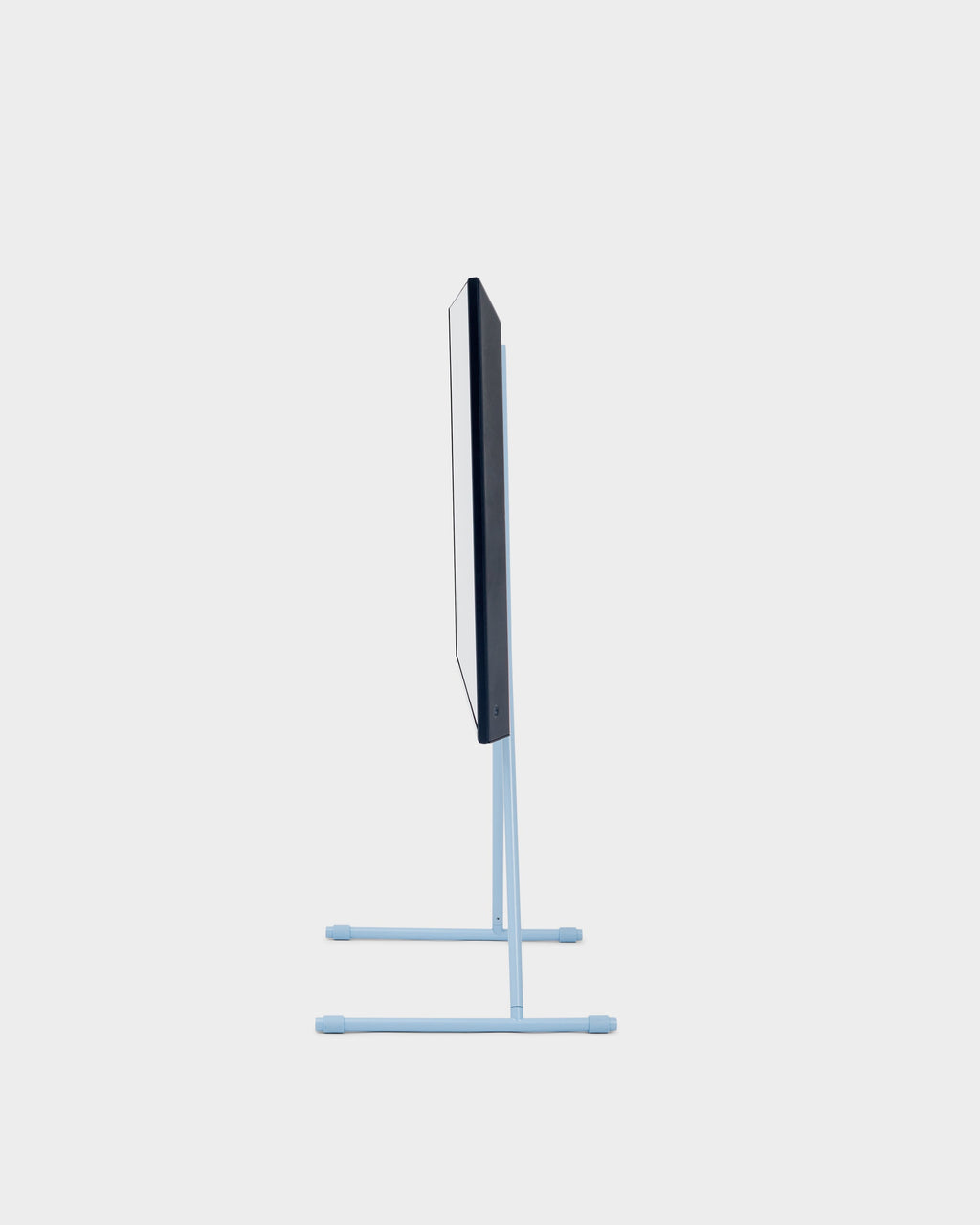 Side profile studio view of the Viva TV stand in Powder Blue with mounted flat-screen TV on twin T-shaped feet