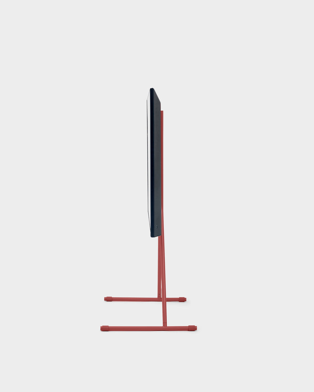 Side profile studio view of the Viva TV stand in Burnin' Red with slim T-base legs holding a mounted flat-screen TV