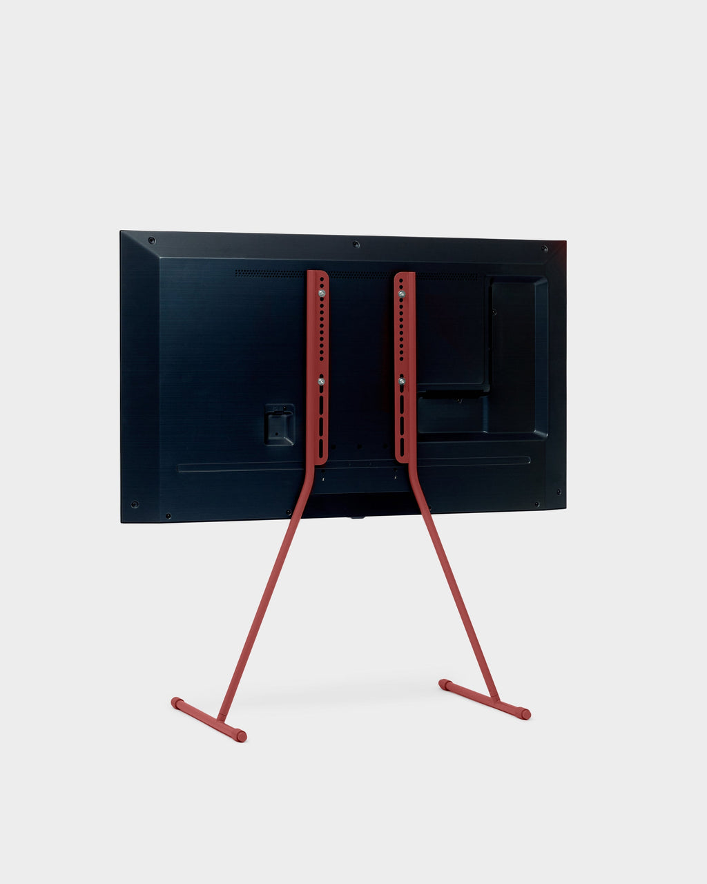 Rear three-quarter studio view of the Viva TV stand in Burnin' Red with a mounted flat-screen TV on splayed legs