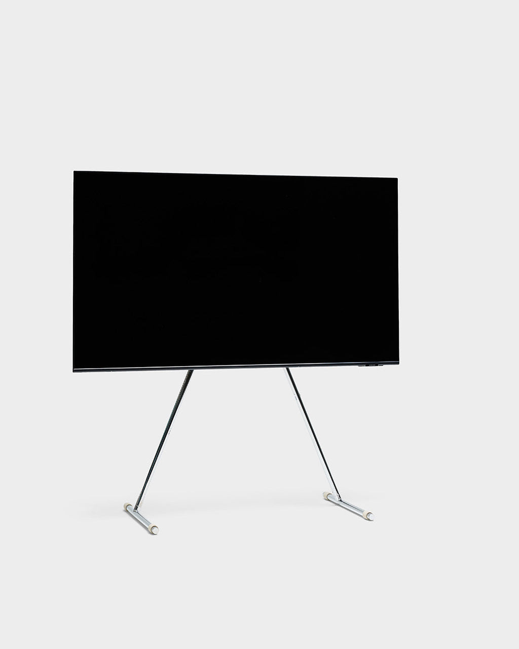 Viva TV stand in Chrome holding a large flat-screen TV, angled studio packshot on a light grey background